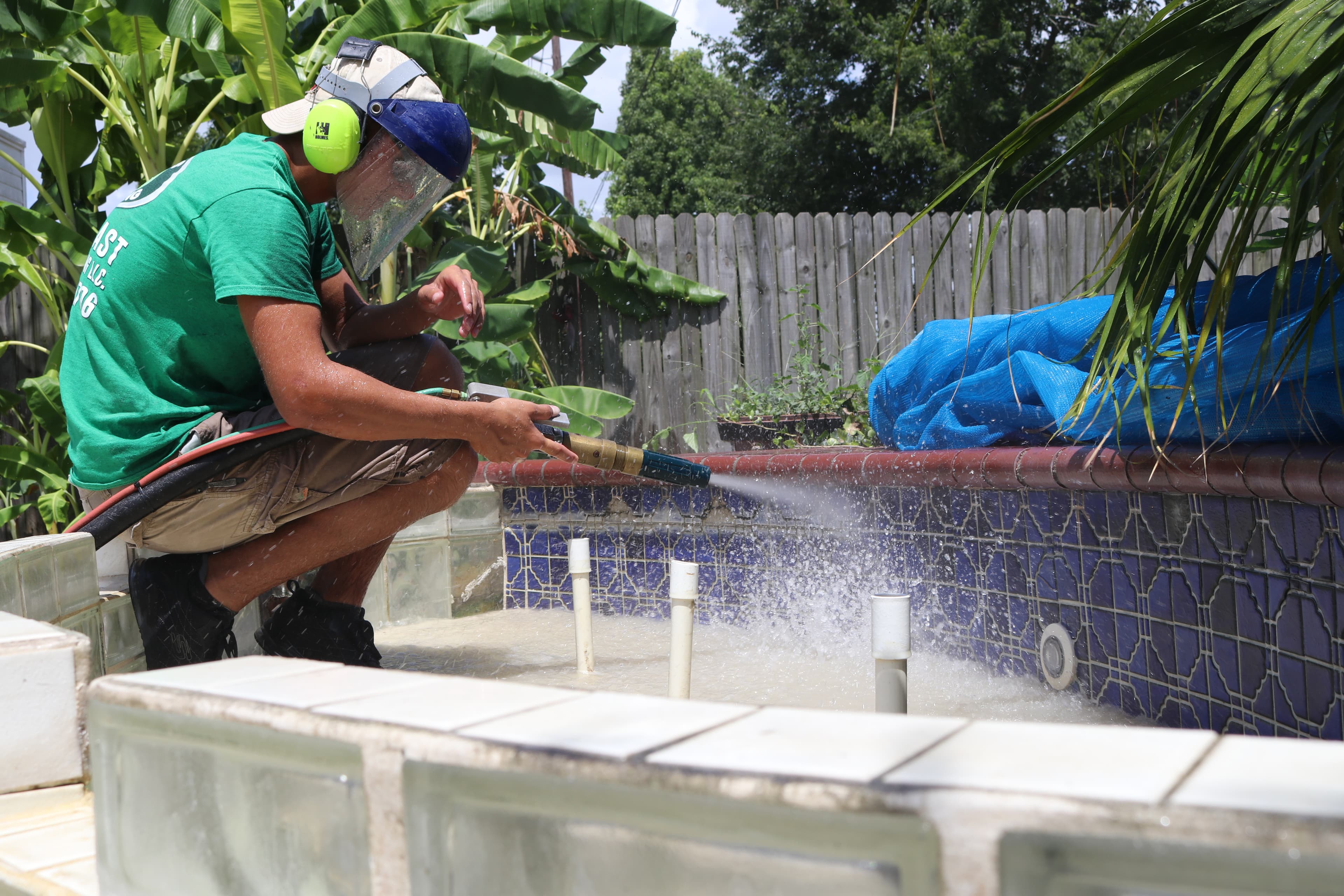 Technician cleaning tile around a residential pool